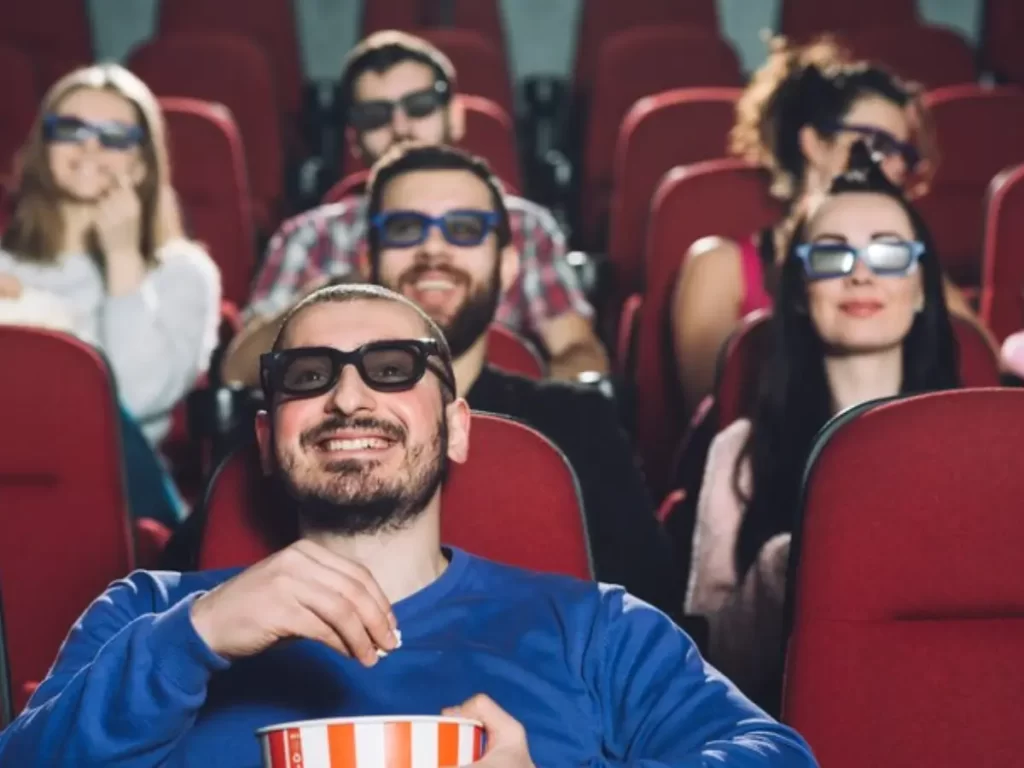 homem assistindo filme no cinema