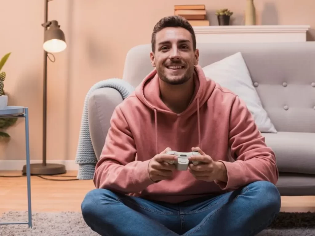 homem com controle na mão e olhando a tv