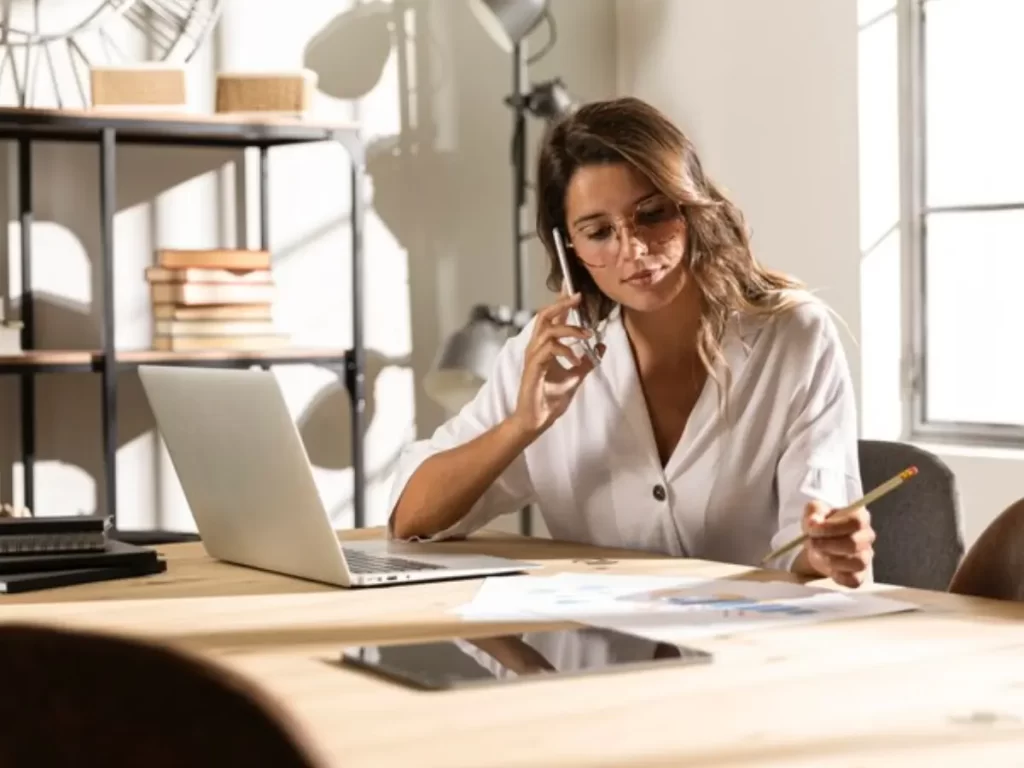 mulher no meio do tiro falando ao telefone na mesa