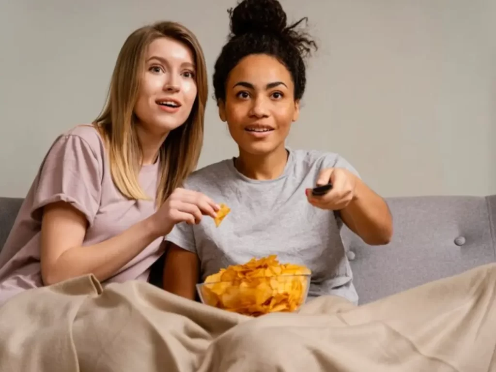 amigas comendo pipoca enquanto assistem série