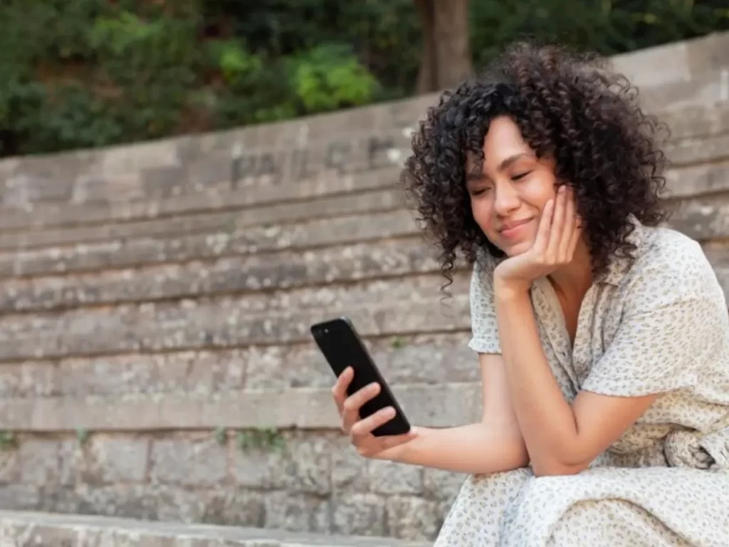 mulher de cabelo cacheadp postando nas redes sociais