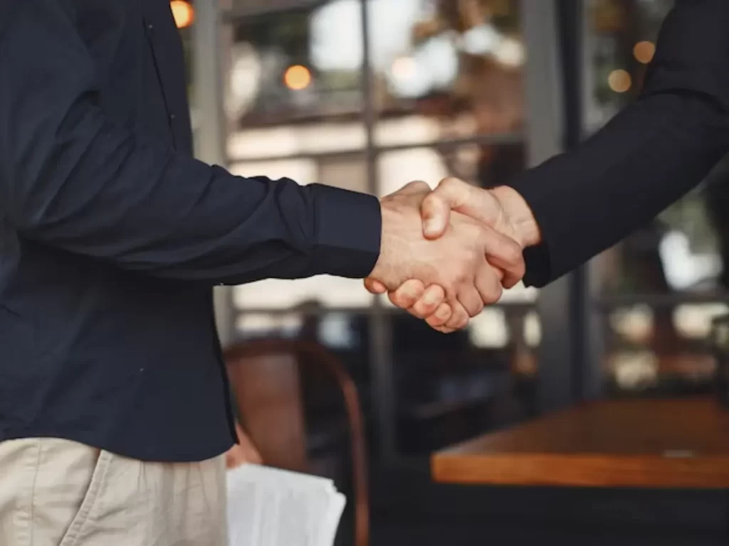 dois homens apertando as mãos para fechar um acordo