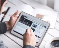 Homem mexendo no computador e tomando café