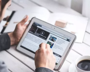 Homem mexendo no computador e tomando café