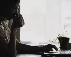 Mulher tomando café enquanto trabalha