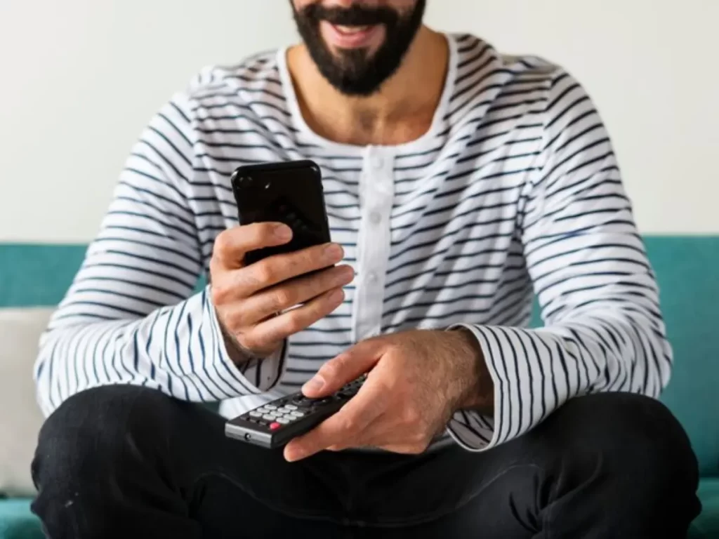 homem adulto segurando celular na mão