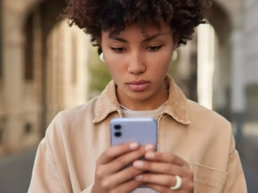 jovem séria mexendo no celular