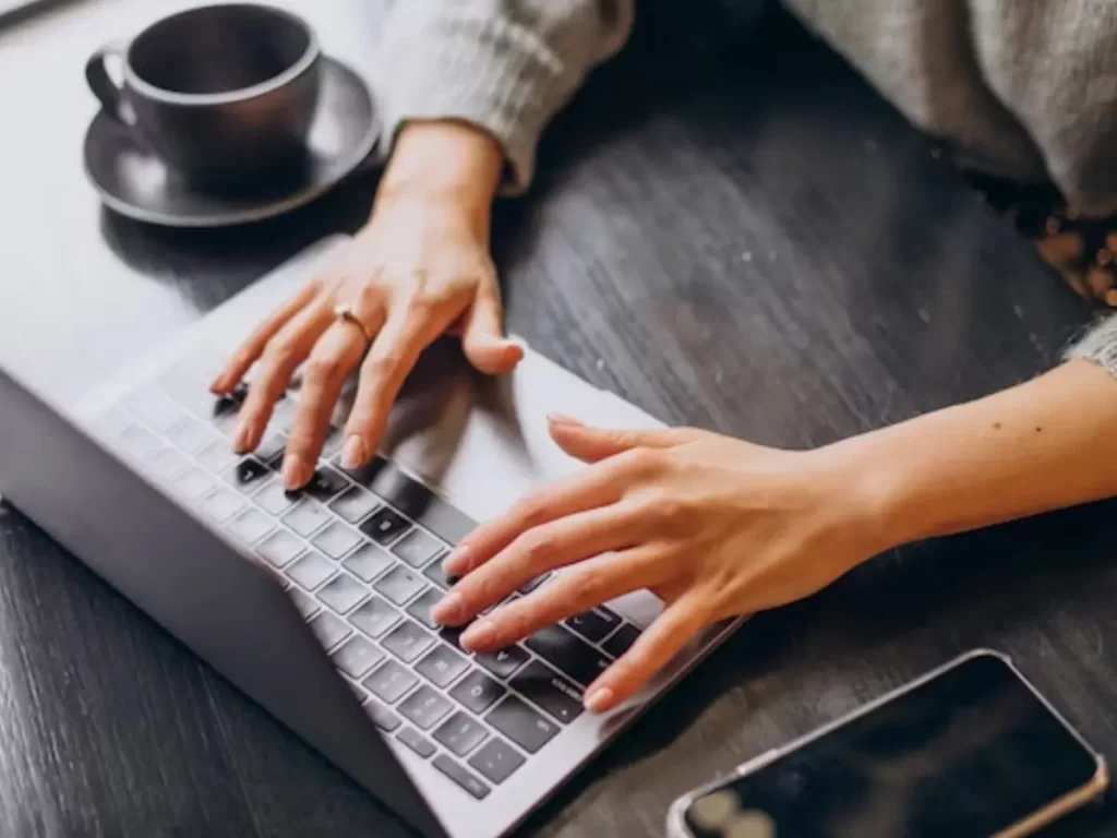 mãos femininas digitando no teclado do computador