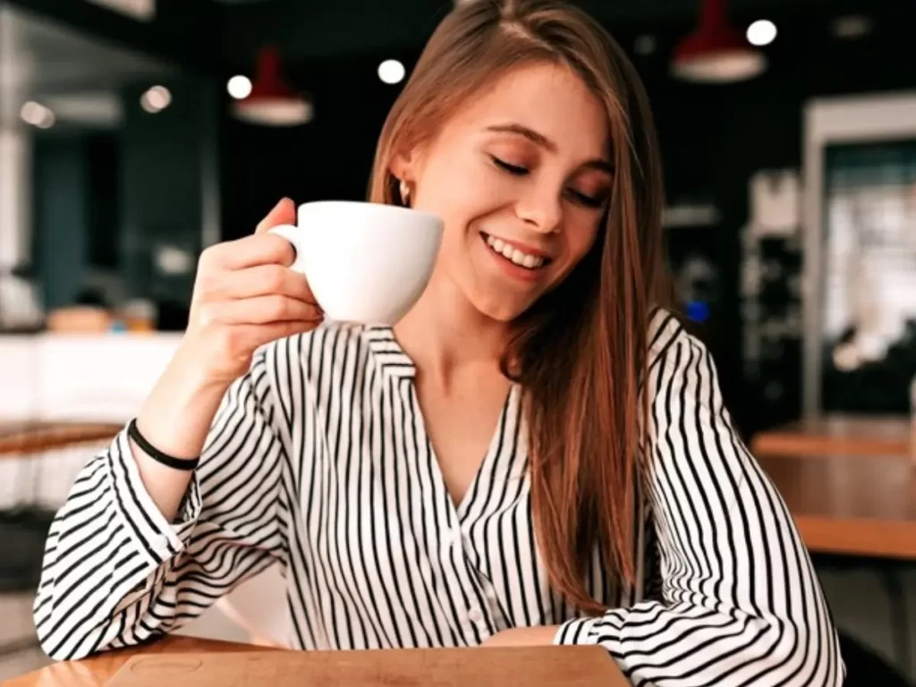 mulher de cabelos compridos tomando café