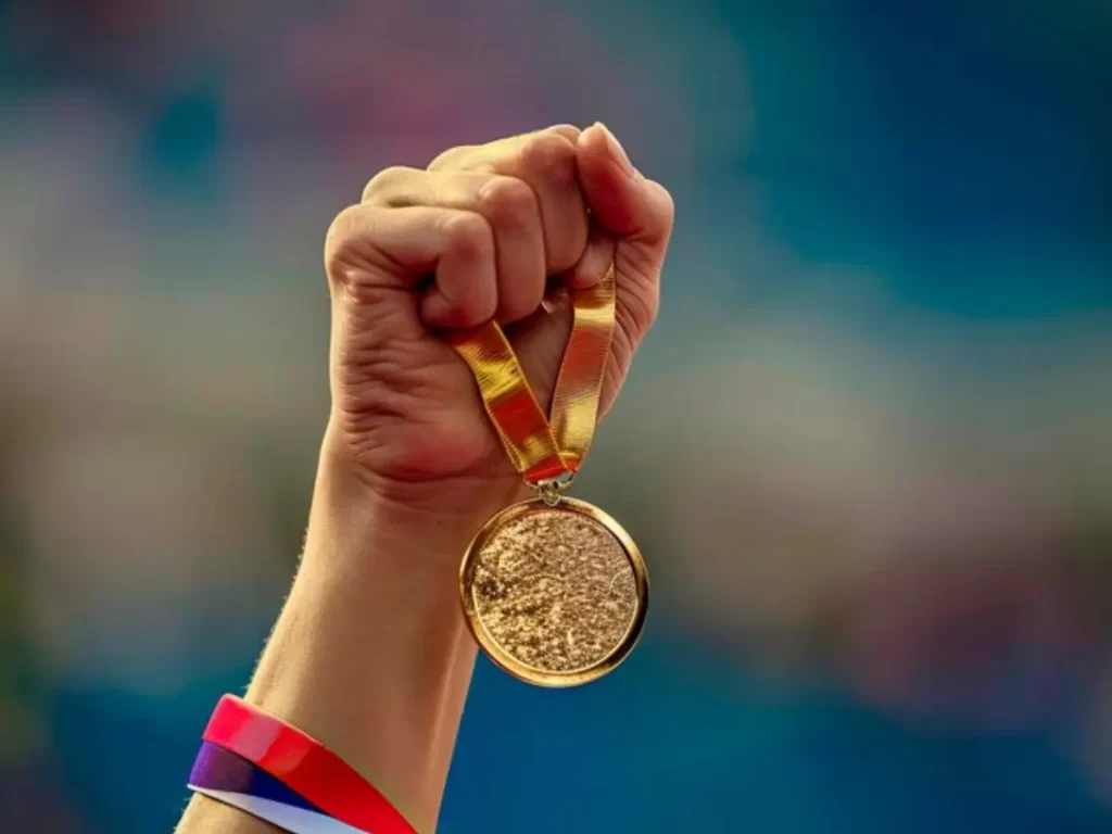 mão erguida com medalha na olimpiada