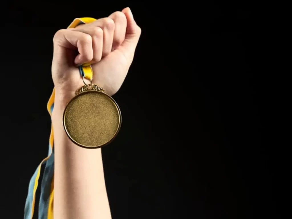 pesso segurando medalha de ouro nas olimpiadas