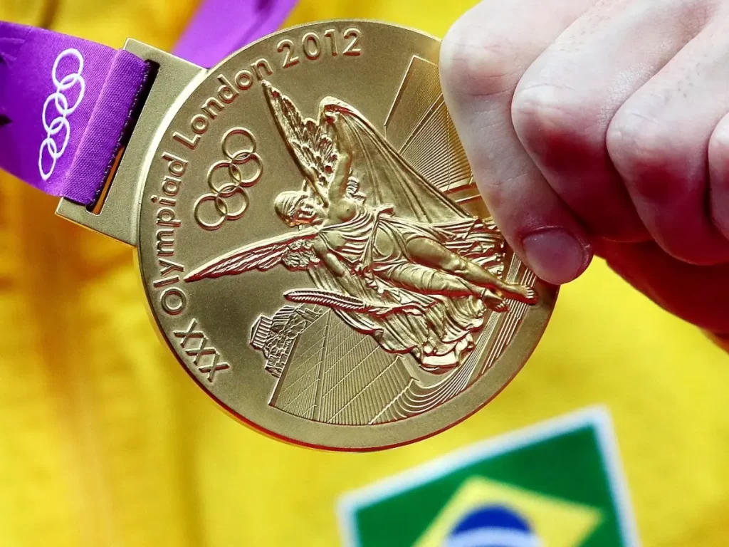 brasileiro segurando medalha de ouro olimpica